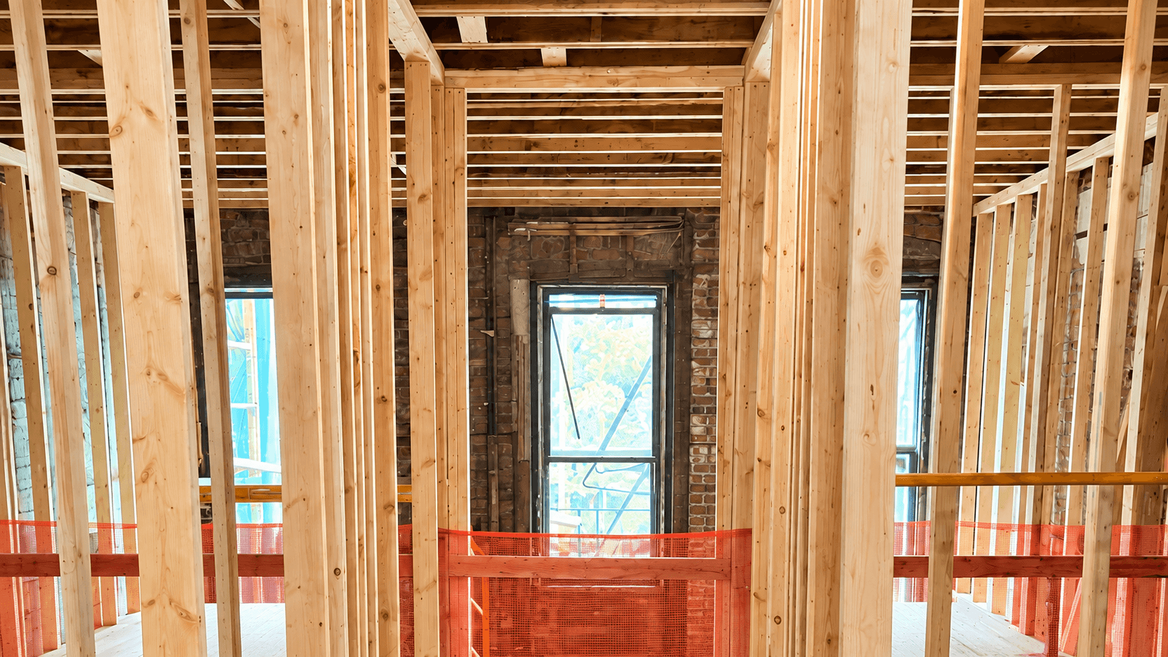 New timber framing and ceiling joists inside an unfinished brick building